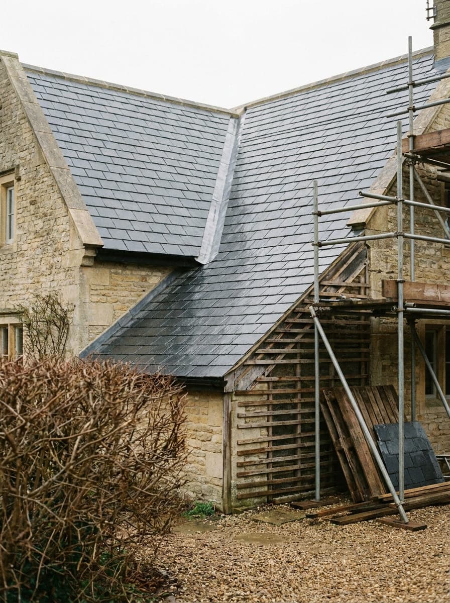 A completed re-slated roof on a period British cottage seen from the drive